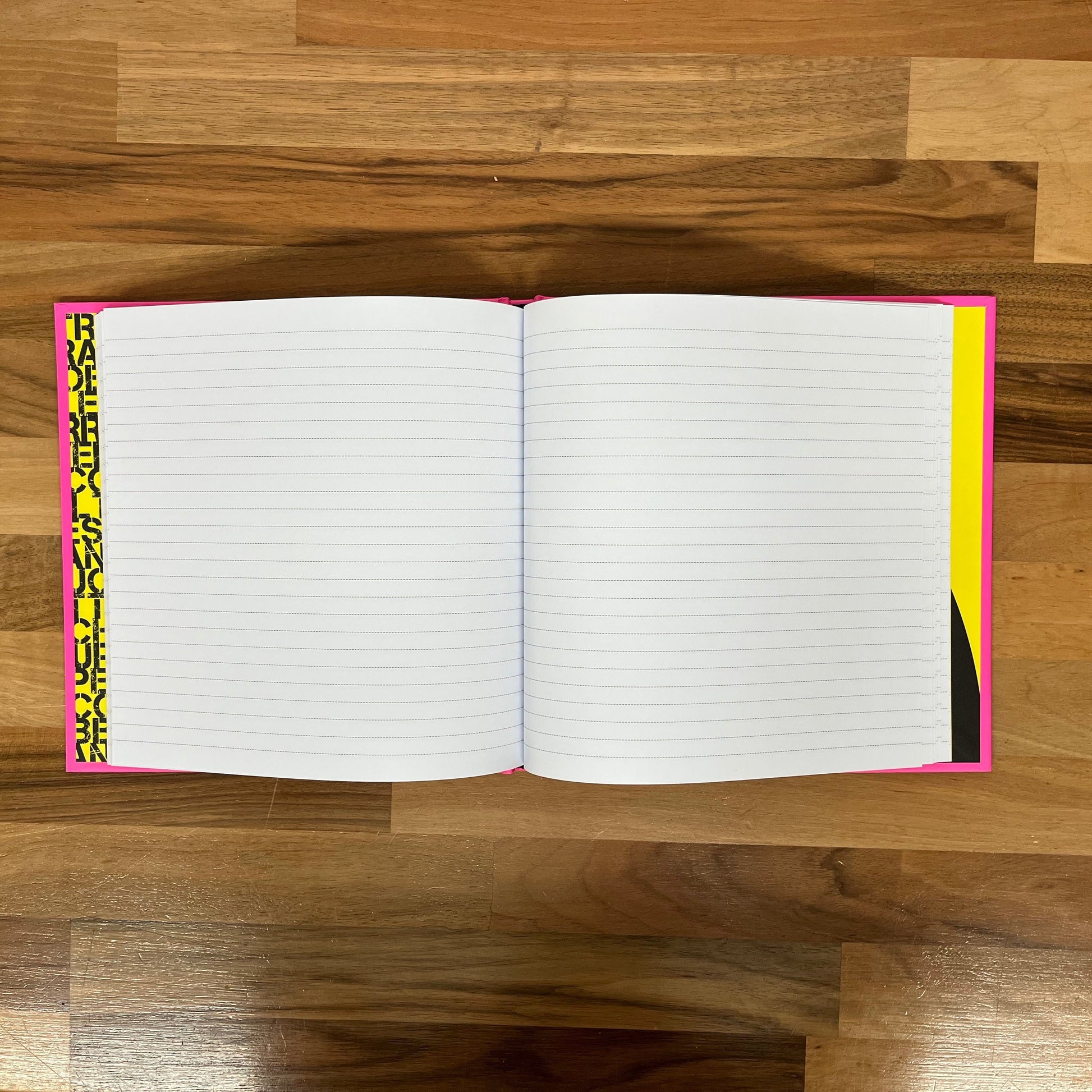 Open notebook with lined pages on a wooden floor